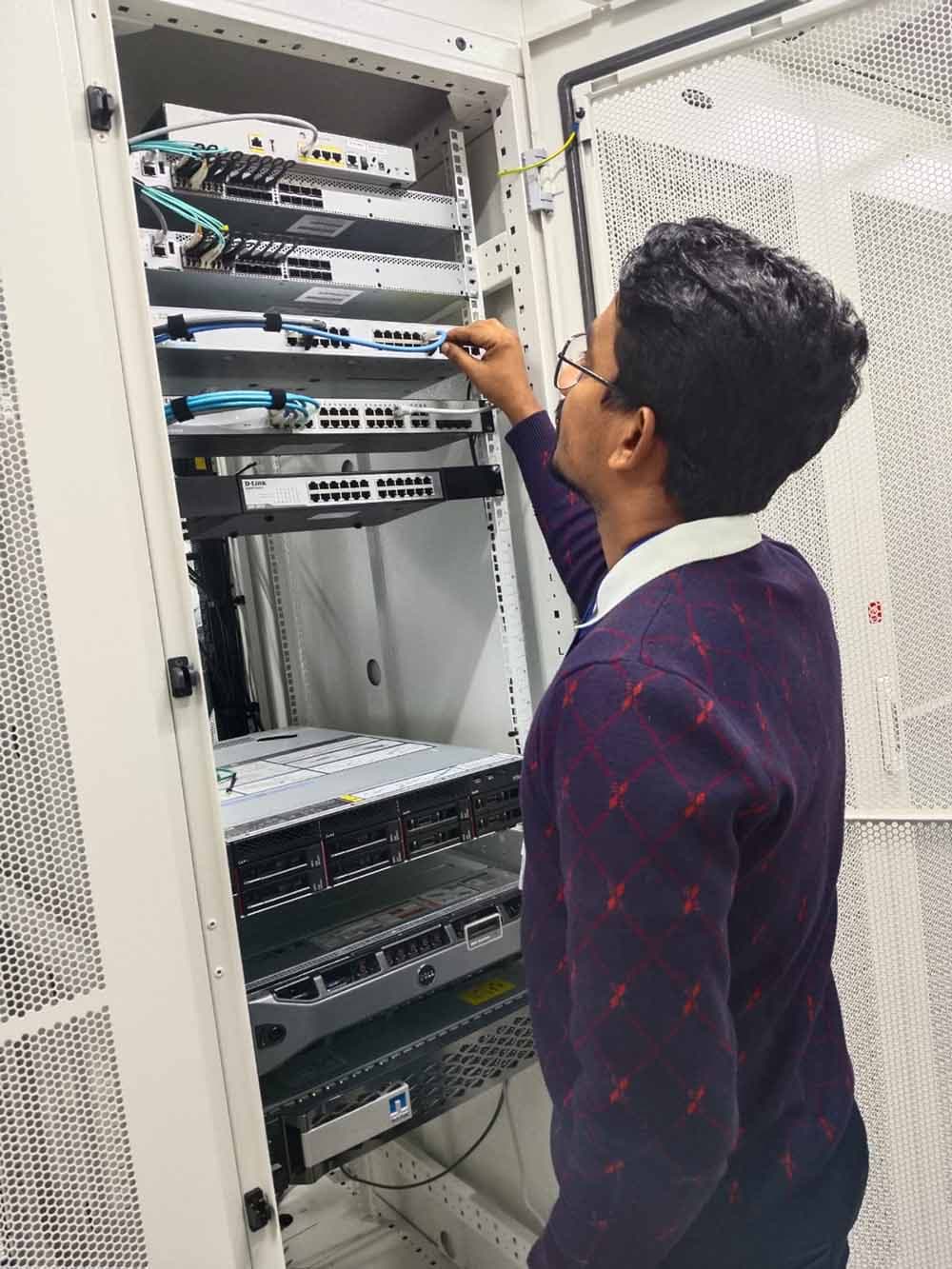 Technician handling network and server equipment during IT asset relocation