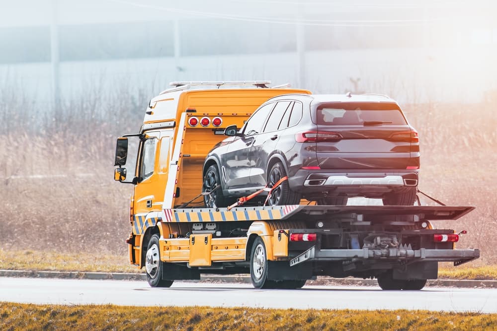 Car secured on a specialized carrier for vehicle relocation